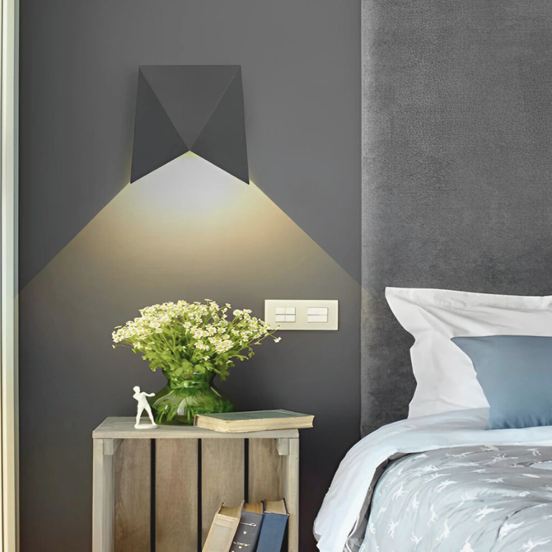 Creative Geometric LED Wall Sconce in bedroom with a nightstand.
