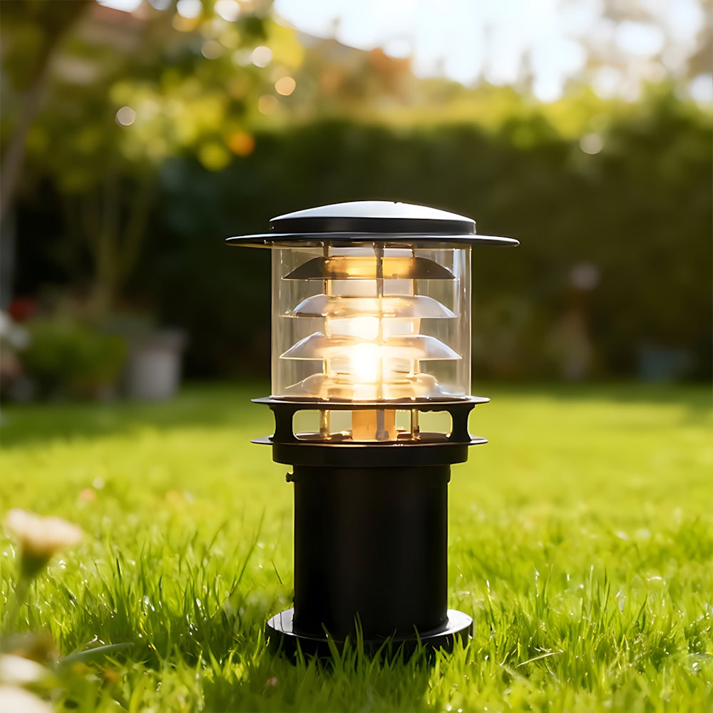 Luxe Aura Waterproof Outdoor Light in Aluminum with Acrylic Finish, black, illuminated, standing in green grass during the day, with a blurred garden background. Ideal for pathway or garden illumination.