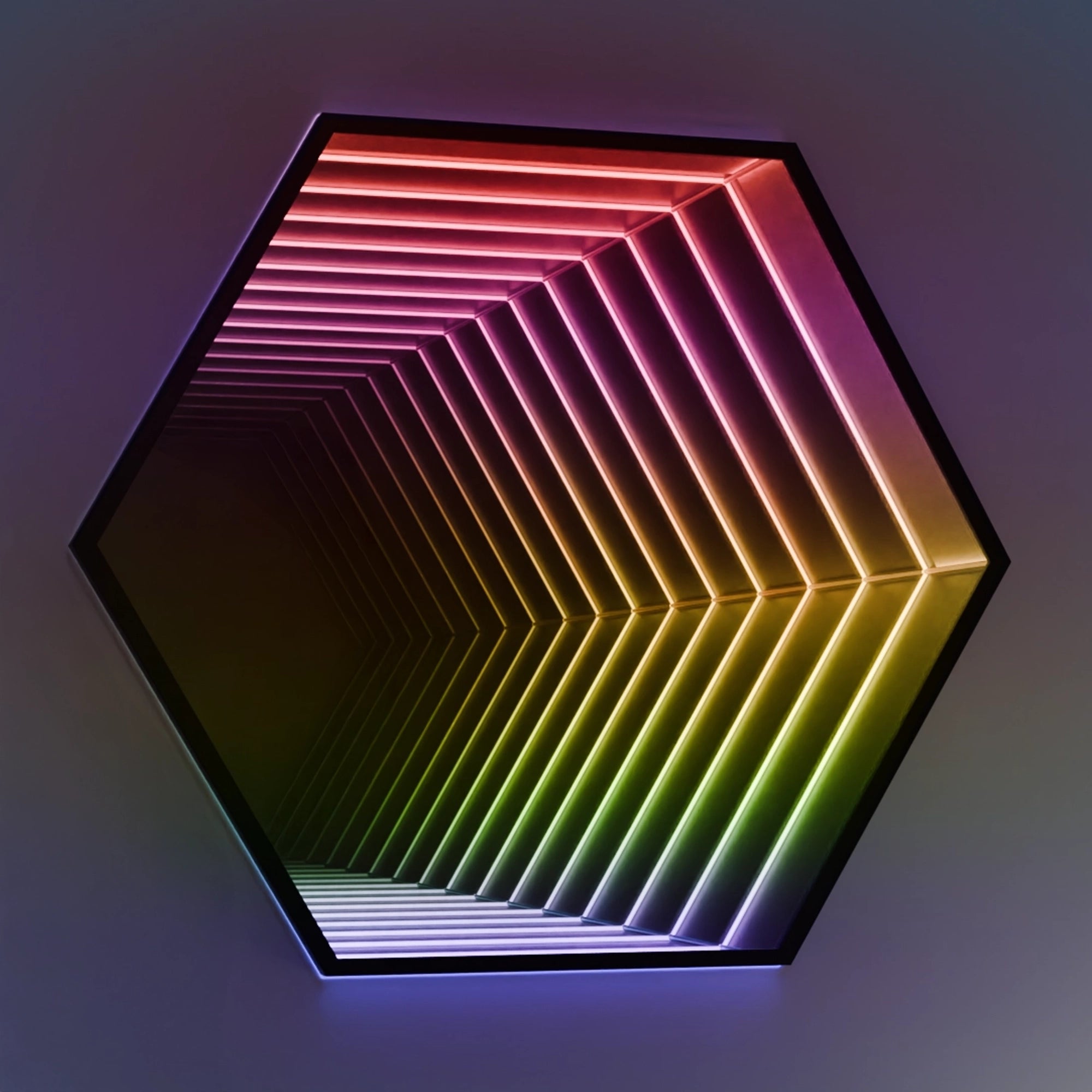 Hexagonal infinity mirror LED wall light displaying a vibrant rainbow gradient of colors, creating a deep tunnel effect.
