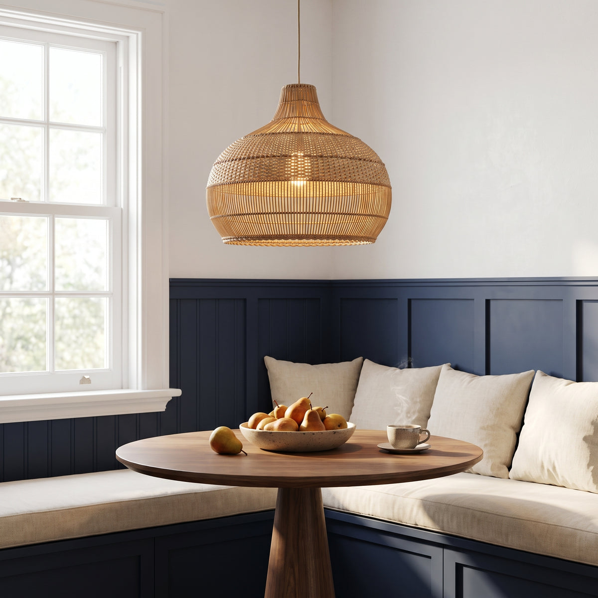 Rattan pendant lamp shade above a walnut table in a New England breakfast nook with navy wainscoting