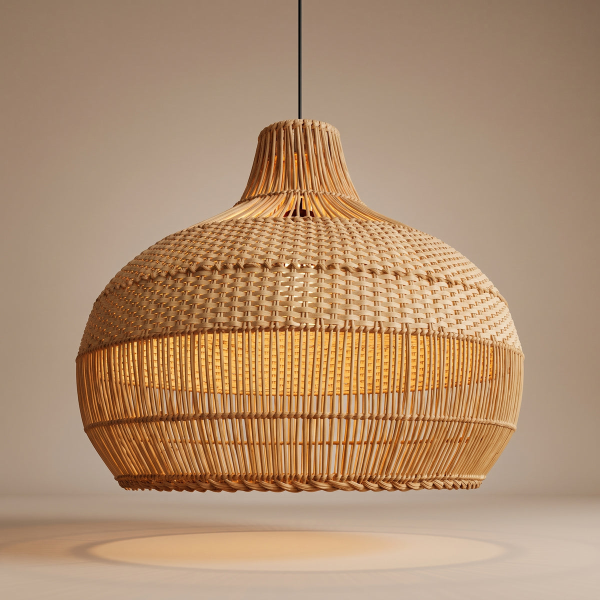 Handwoven rattan bulb-shaped pendant lamp shade lit with a warm glow, front view on a beige studio background