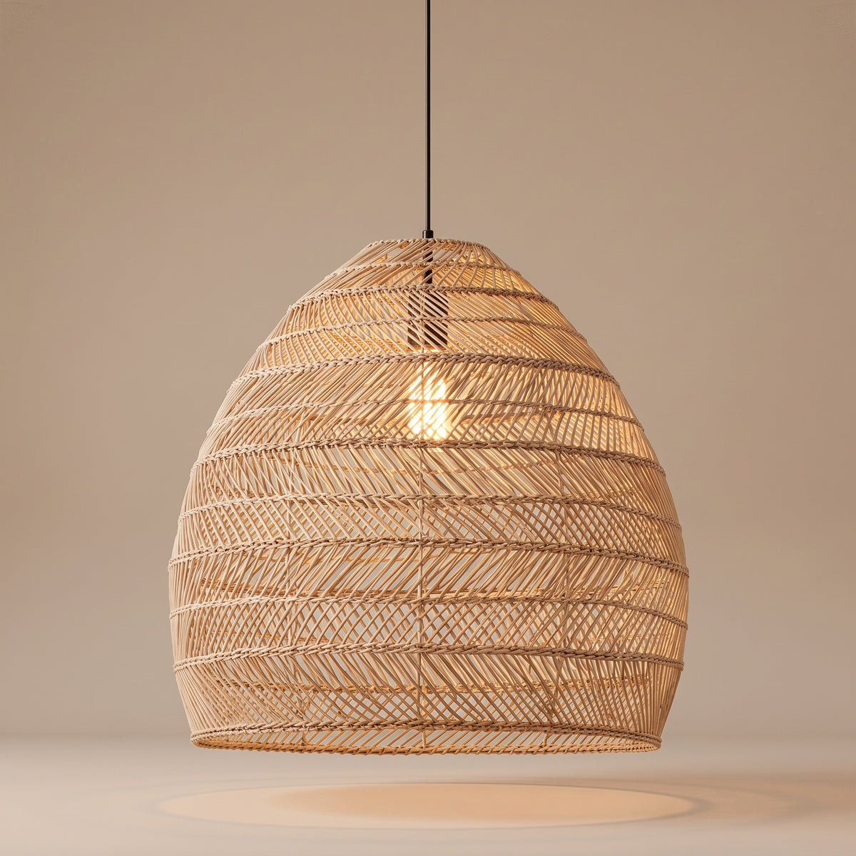 Handwoven wicker cloche pendant lamp shade lit with a warm glow on a beige studio background