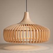 Handcrafted curved wood slat pendant lamp shade lit with a warm glow on a beige studio background