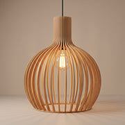 Handcrafted wooden slat cage pendant lamp shade lit with a warm glow on a beige studio background