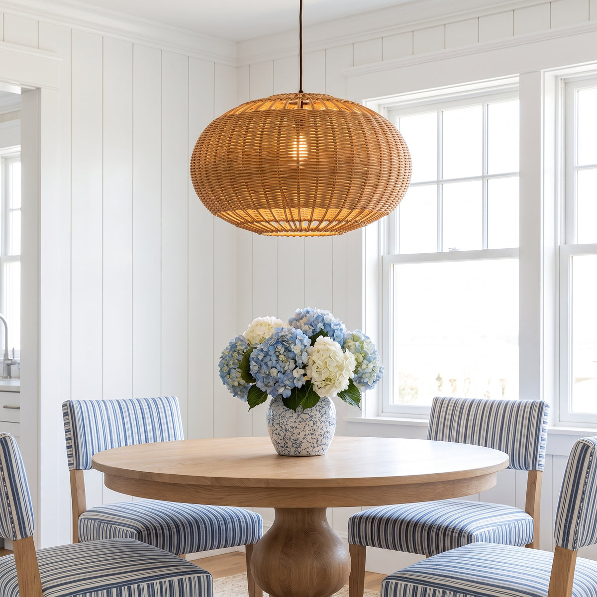 Wide wicker globe pendant lamp shade above a Nantucket dining table