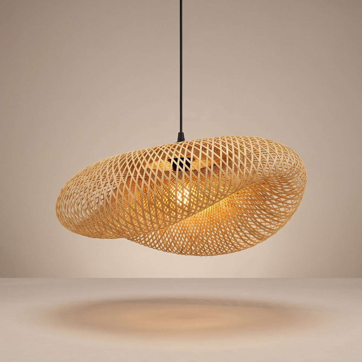 Handwoven sculptural wave bamboo pendant lamp shade lit with a warm glow on a beige studio background