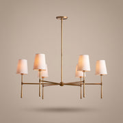Belmont brass chandelier with linen drum shades, lit, studio view