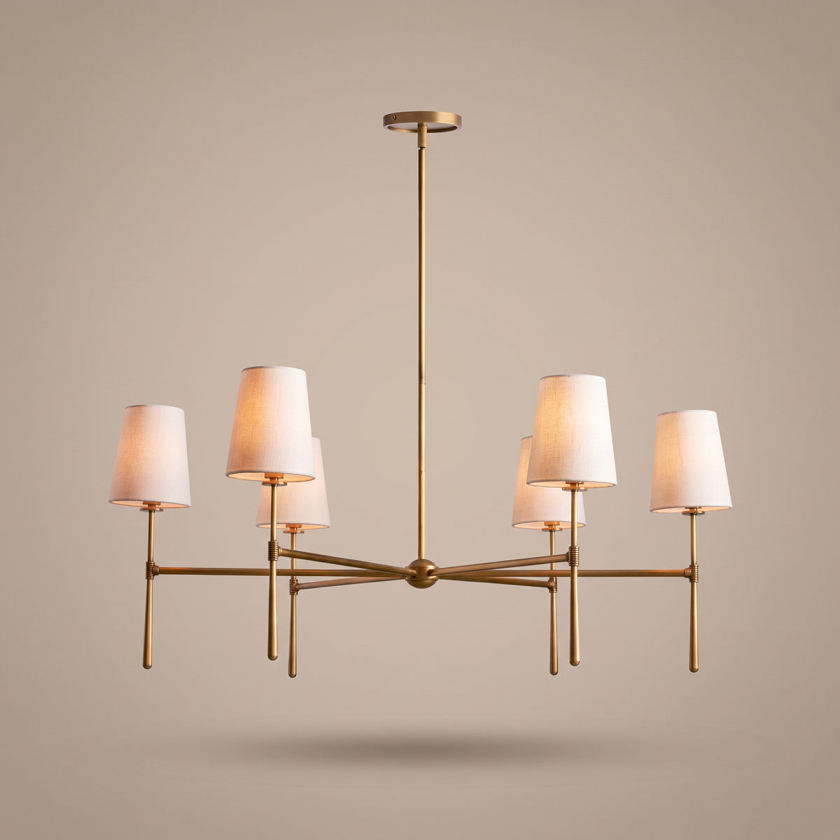 Belmont brass chandelier with linen drum shades, lit, studio view