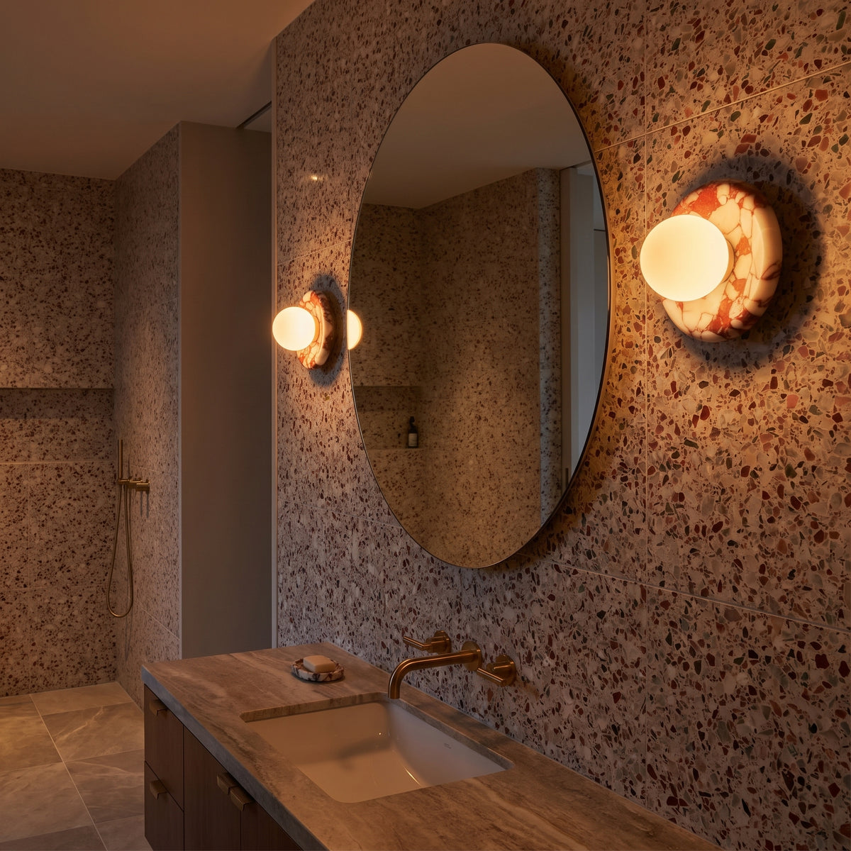 Pair of Rosso marble sconces in a modern bathroom