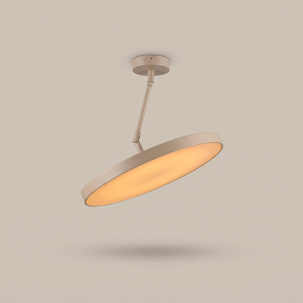 Sway beige tilting disc LED ceiling light on swivel arm, lit, studio view
