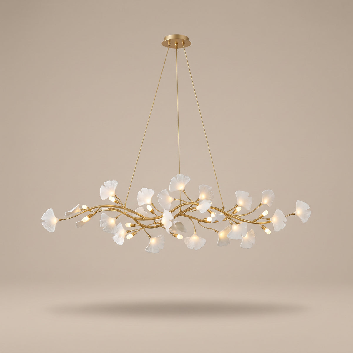Ginkgo gold branch chandelier with white porcelain leaves, lit, studio view