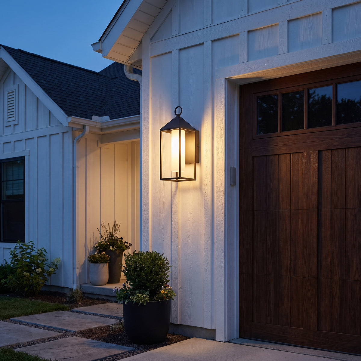 Fanal outdoor lantern beside a farmhouse garage door at dusk