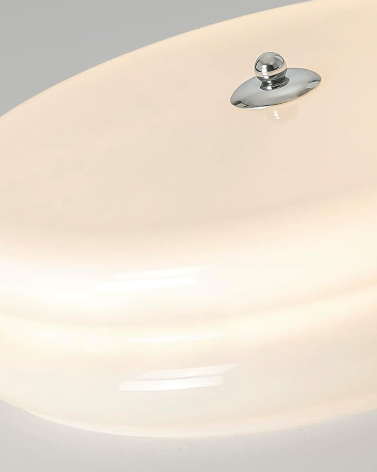 Very close-up detail of the illuminated Époque glass pendant lamp, showing the white glass shade and chrome finish central knob.