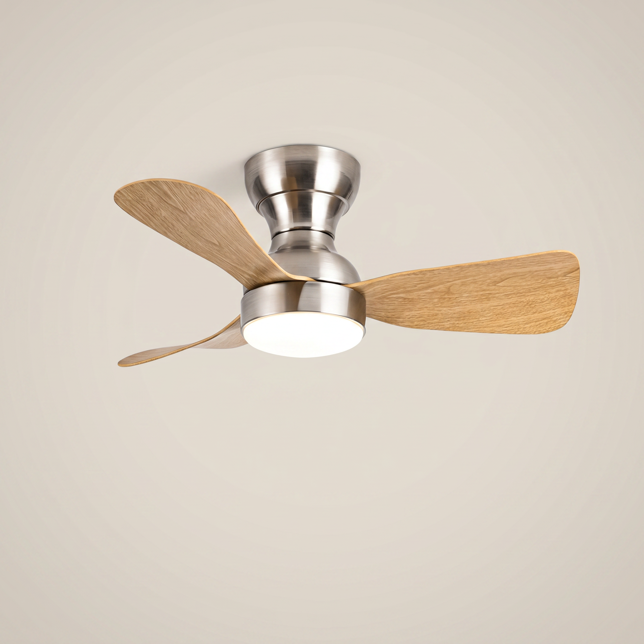 Silver ABS flush mount ceiling light with fan at three-quarter angle with light wood blades lit