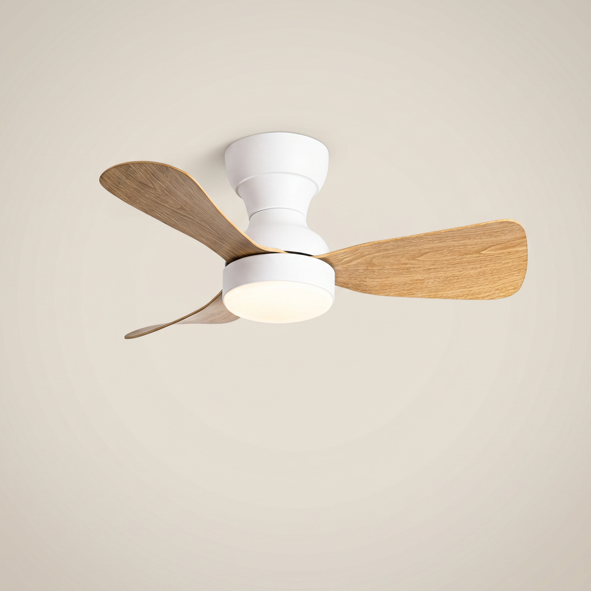 White ABS flush mount ceiling light with fan at three-quarter angle with light wood blades lit
