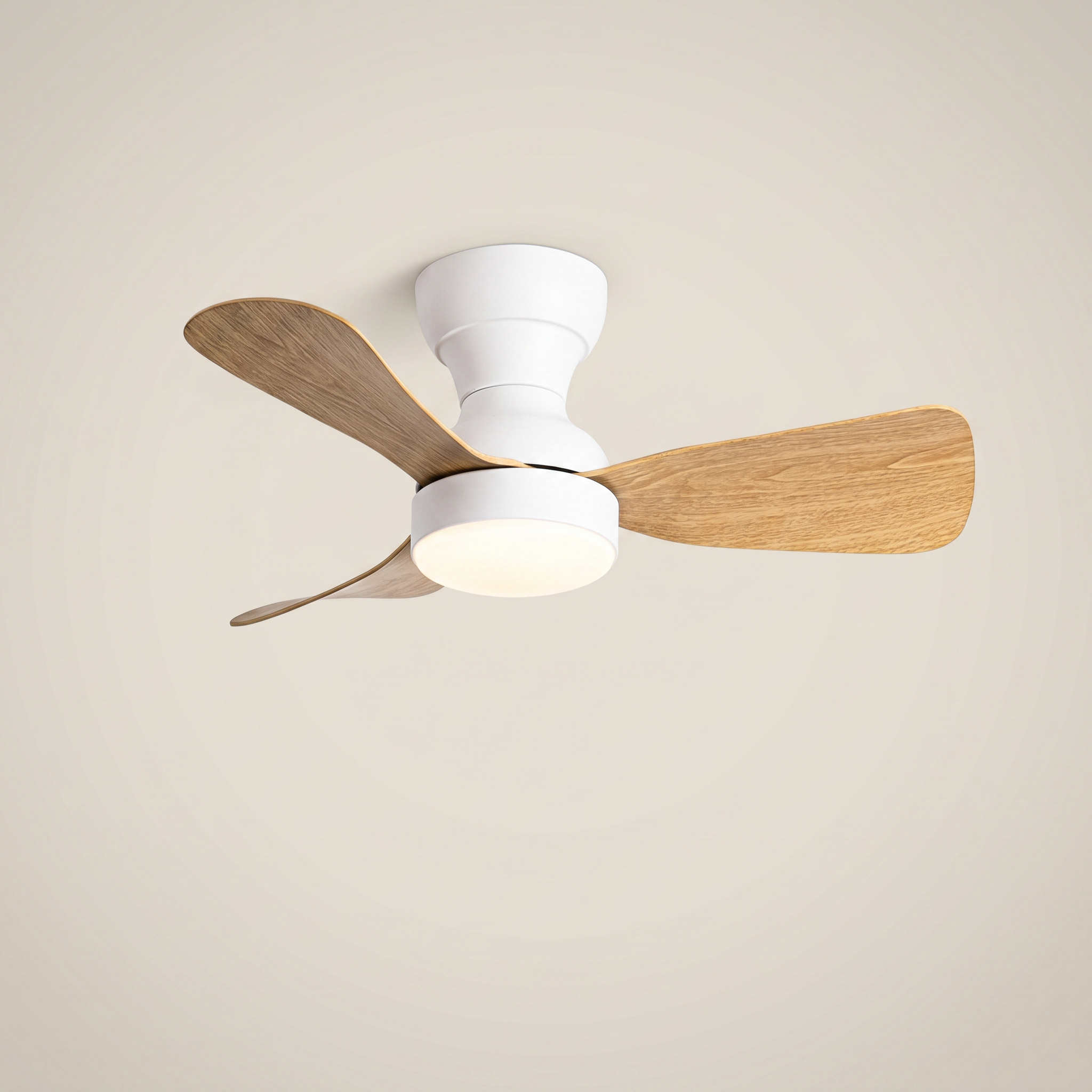 White ABS flush mount ceiling light with fan at three-quarter angle with light wood blades lit