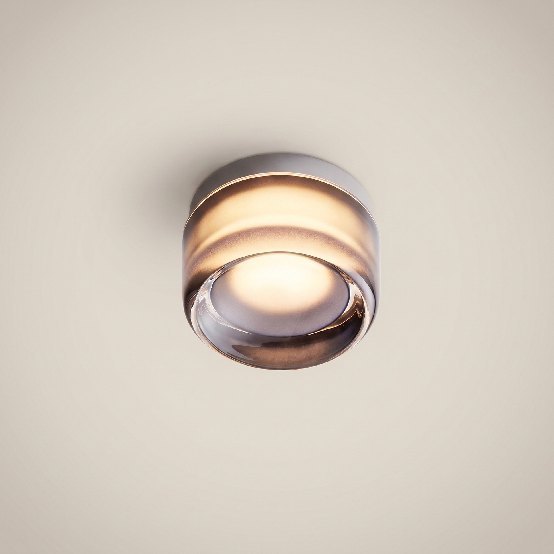 Ambient room shot of Acrylic Smoke Gray Concave three-color dimming 1-light wall sconce glowing warm light with smoke gray acrylic and brushed aluminum trim