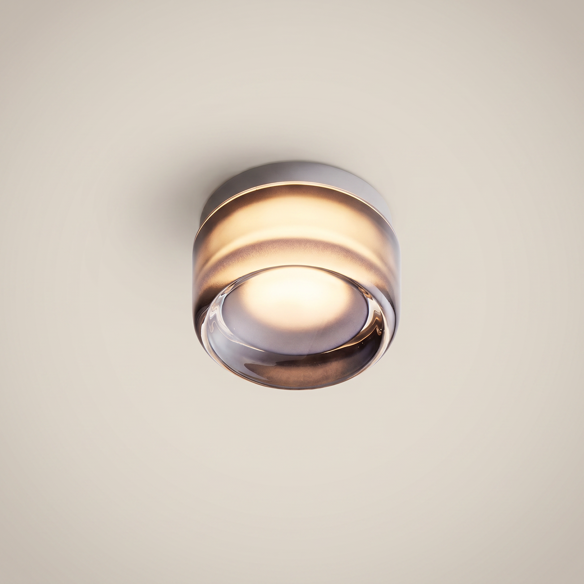 Ambient room shot of Acrylic Smoke Gray Concave three-color dimming 1-light wall sconce glowing warm light with smoke gray acrylic and brushed aluminum trim