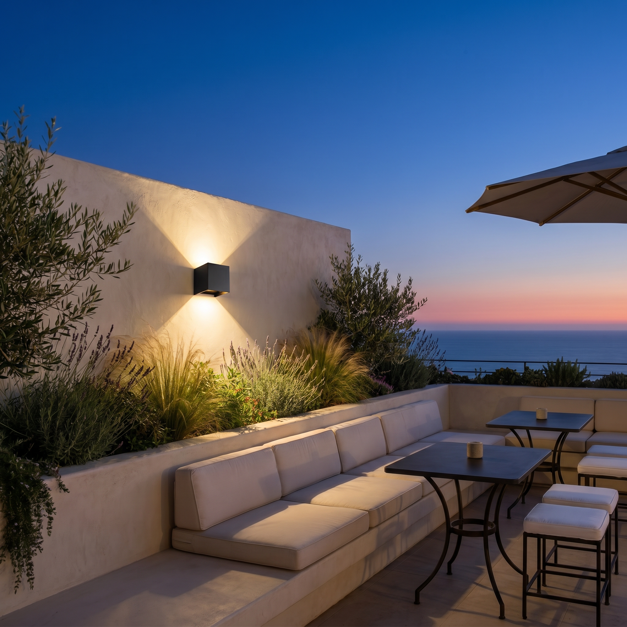 Black aluminum square outdoor wall sconce shown from low angle lit on balcony wall with warm white dimmable lighting