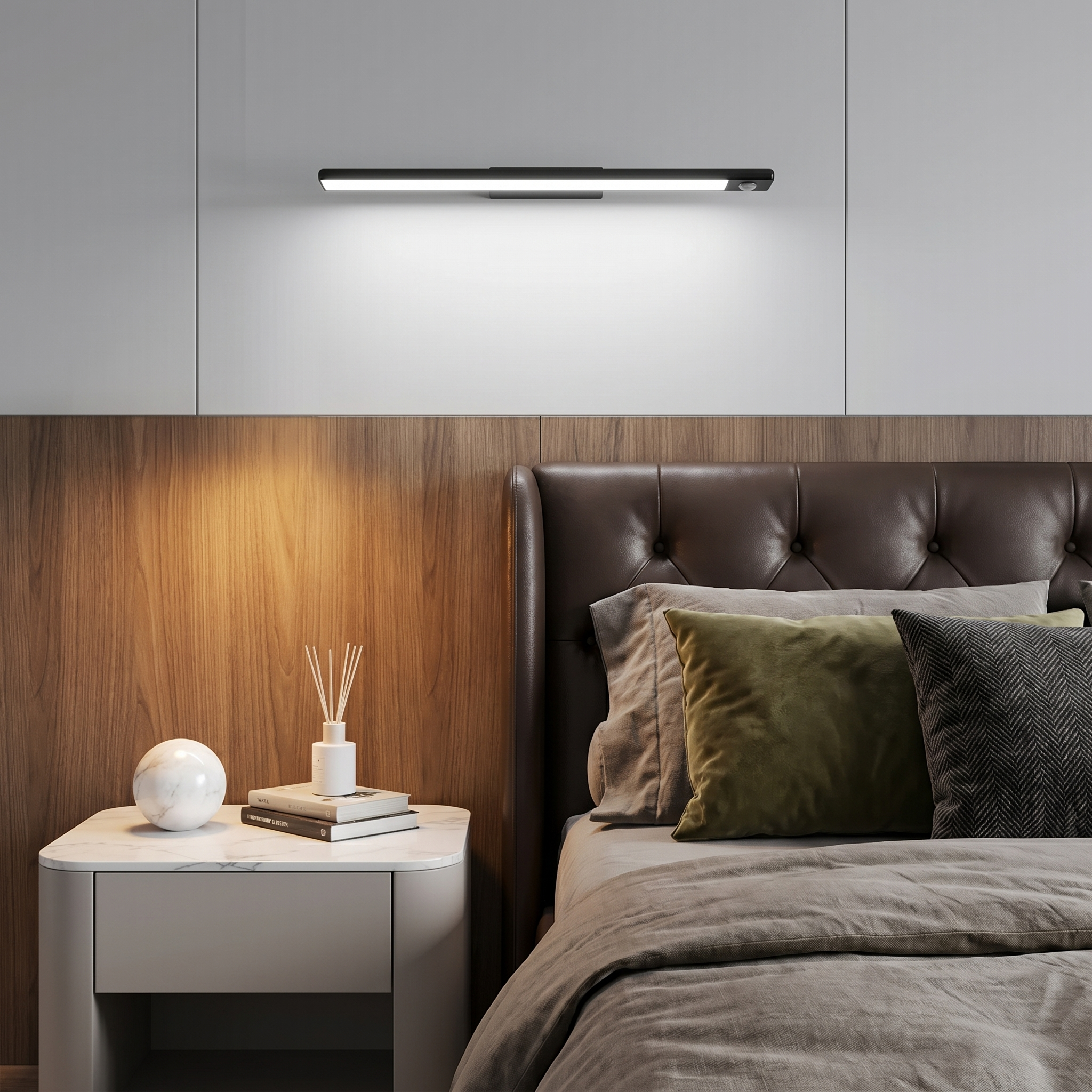 Close-up of aluminum silver linear motion sensor rechargeable under cabinet light glowing warm light on bedroom nightstand with magnetic attachment