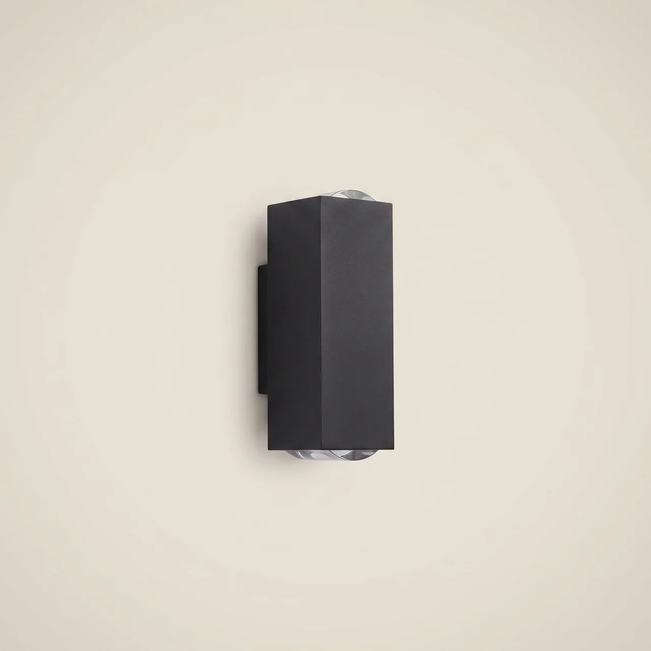 Black aluminum three-beam LED wall sconce at three-quarter angle switched off in outdoor corridor highlighting die-cast aluminum