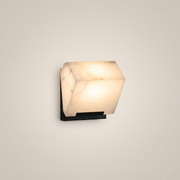 Black faux marble resin single-head LED wall sconce front view showing black iron body and lit faux marble shade with warm light
