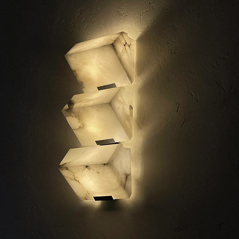 Front view of black faux marble resin single-head LED wall sconce unlit showing black iron body and natural texture of faux marble shade