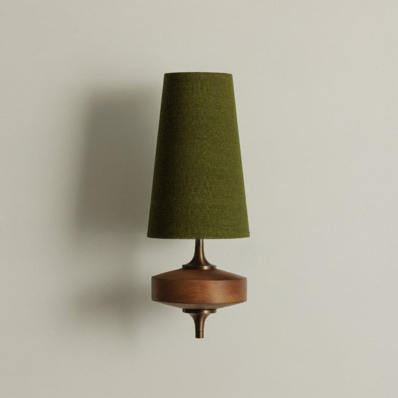 Eldoria Vintage Brass Wall Lamp with Antique Finish, one head, green fabric shade, walnut wood base, and brass accents mounted on a light gray wall.