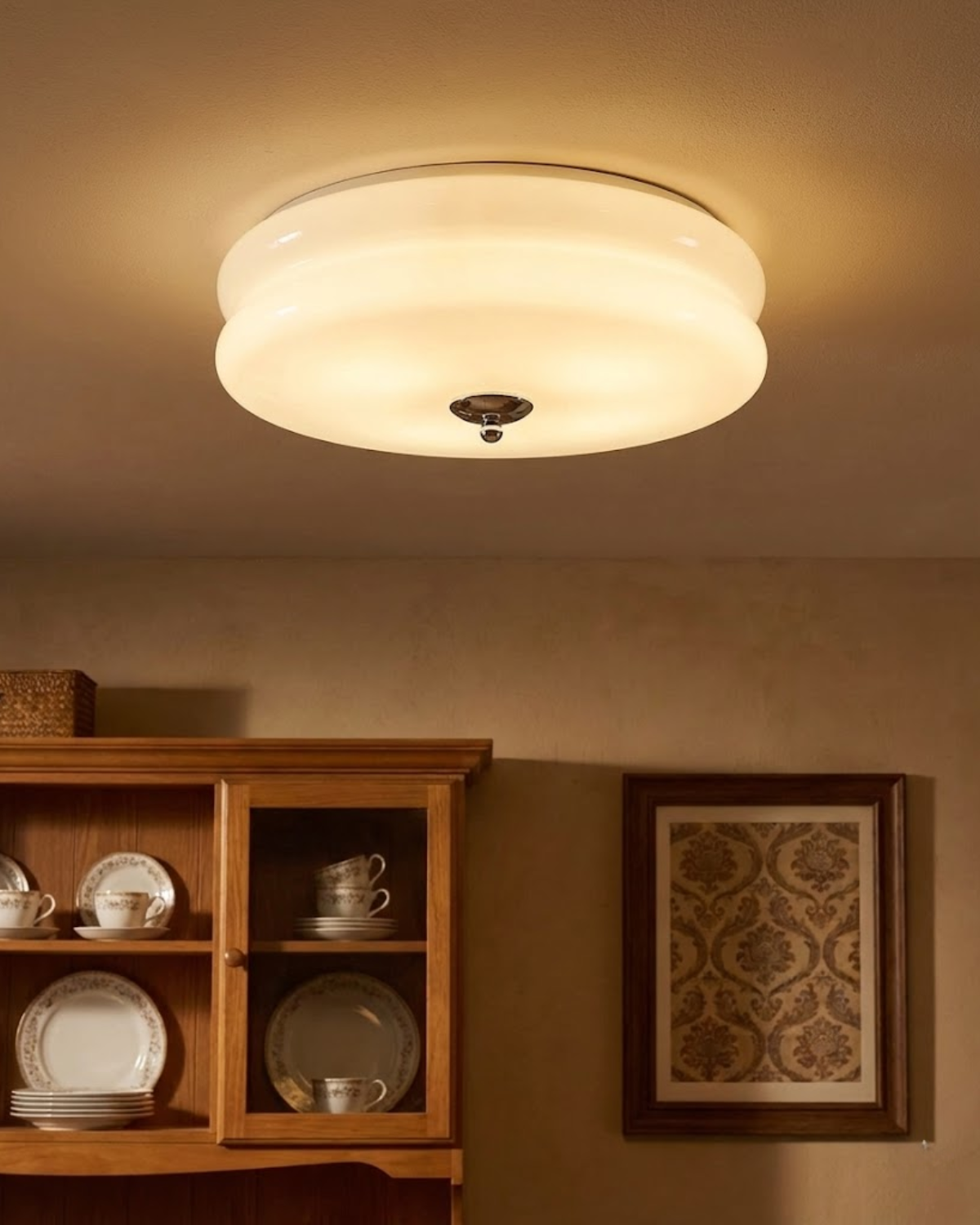 Close-up view of the Époque glass pendant lamp with brass finish, showcasing its elegant design, mounted on a ceiling above a wooden hutch with stacked plates.