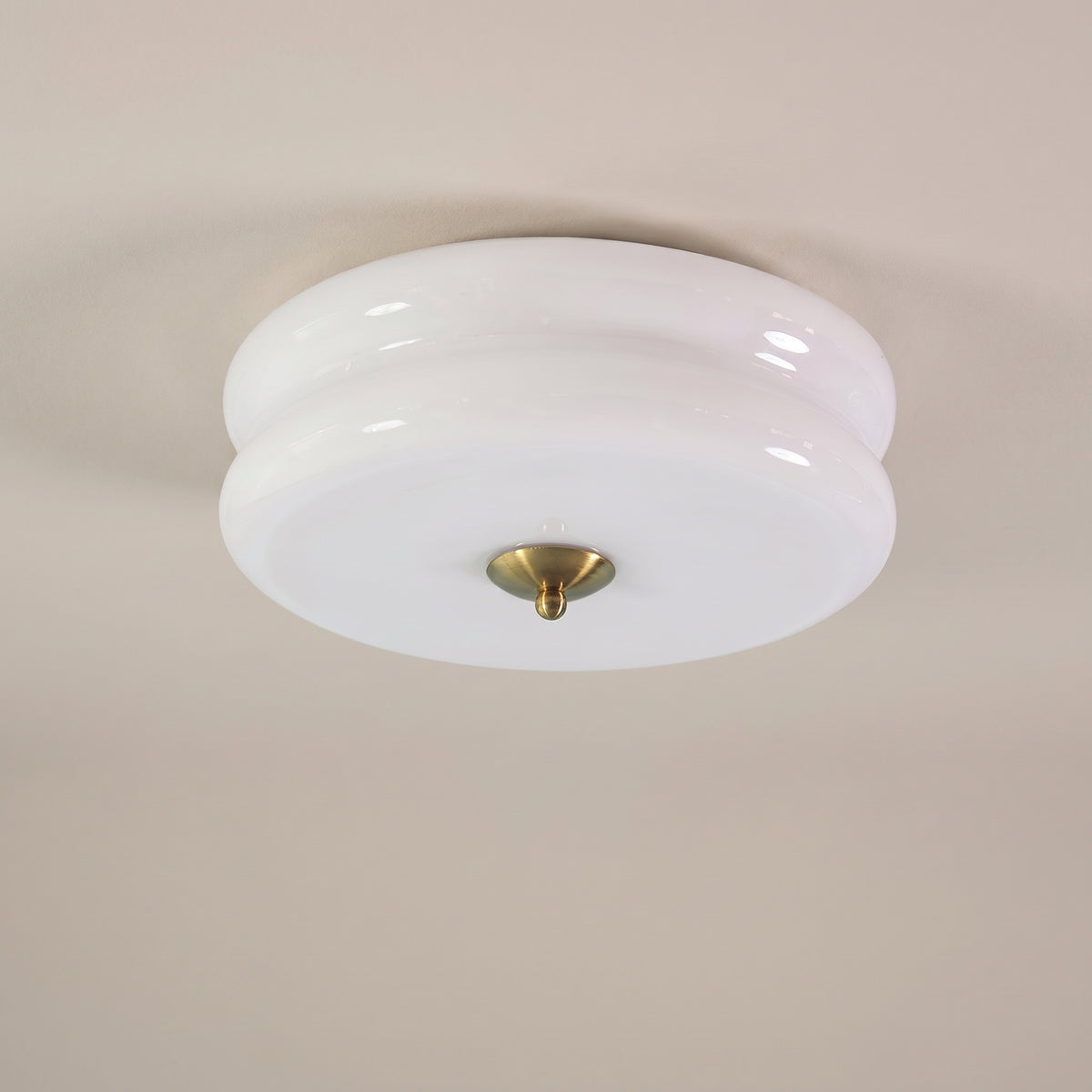Époque glass pendant lamp with white glass shade and brass finish accent, isolated on a black background.