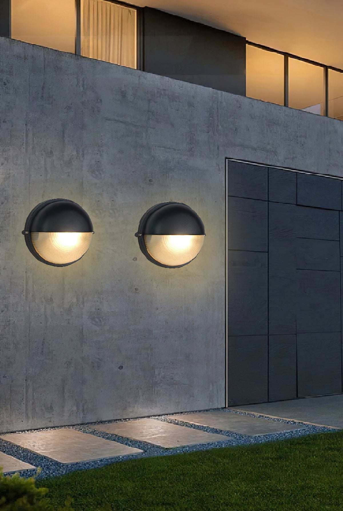 Fenwick Vintage Outdoor Glass Sconce Wall Lamp Metal Frame with Clear Glass, two round black outdoor sconces illuminating a concrete wall at dusk.