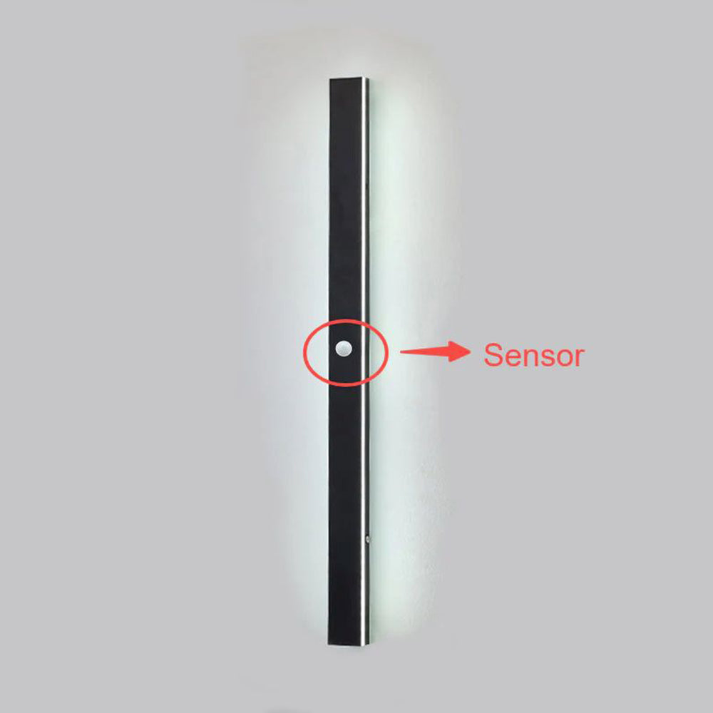 Close-up of the Luna Edge IP65 linear LED wall light in black metal, highlighting the integrated motion sensor with a red circle and arrow.