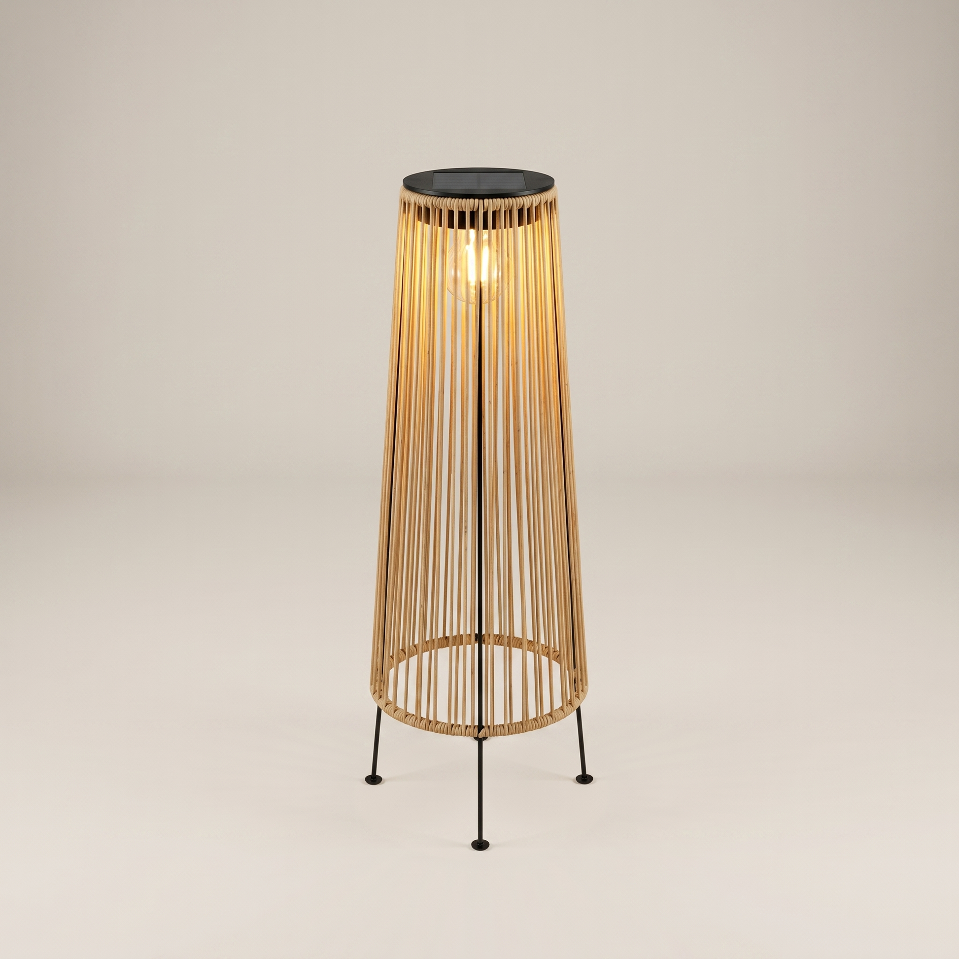 Three-quarter close-up of handwoven rattan geometric solar LED tripod outdoor lantern in natural tan showing tripod iron legs