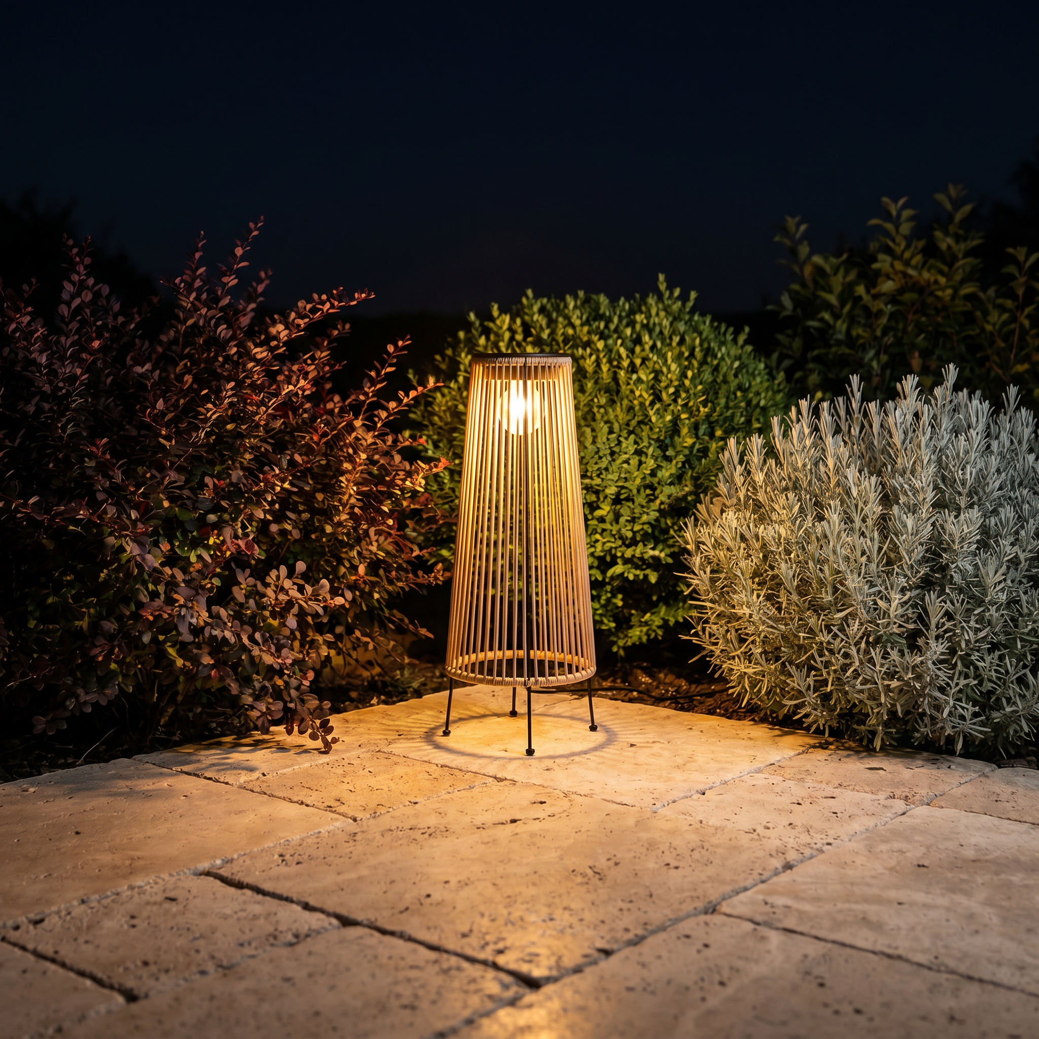 Top-down close-up of handwoven rattan geometric solar LED tripod outdoor lantern showing natural tan finish and solar panel visible