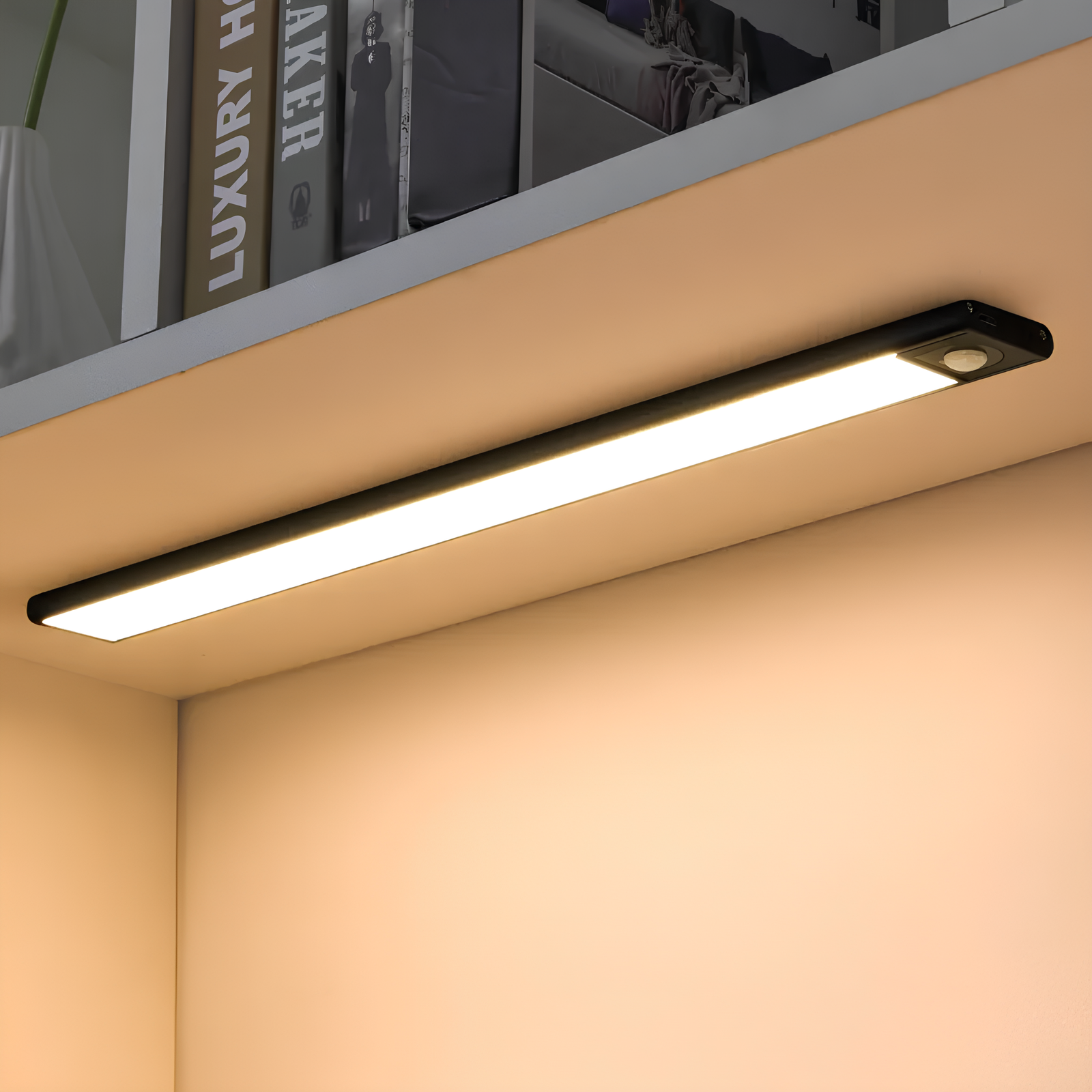 Black Lumos Glow motion sensor light installed under a white shelf, providing bright, energy-efficient LED lighting to illuminate the area below. This easy installation light offers smart, automatic lighting for various indoor spaces.