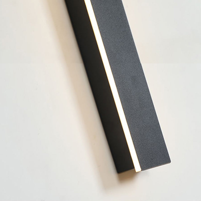 Close-up view of the Luna Edge IP65 linear LED wall light, highlighting the illuminated warm white light strip within its black metal and acrylic finish.