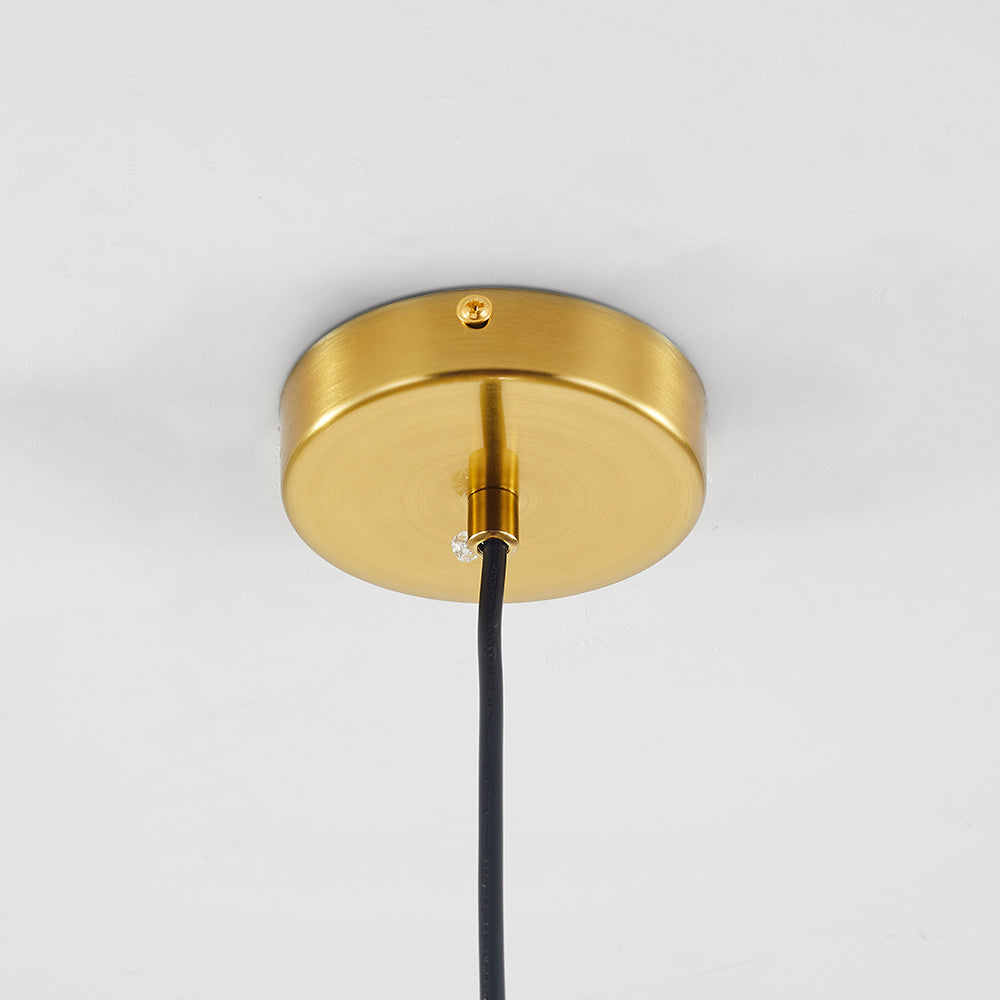 Close-up view of the Lustre Aura LED pendant light's brass ceiling canopy, showing the mounting hardware and black cord.