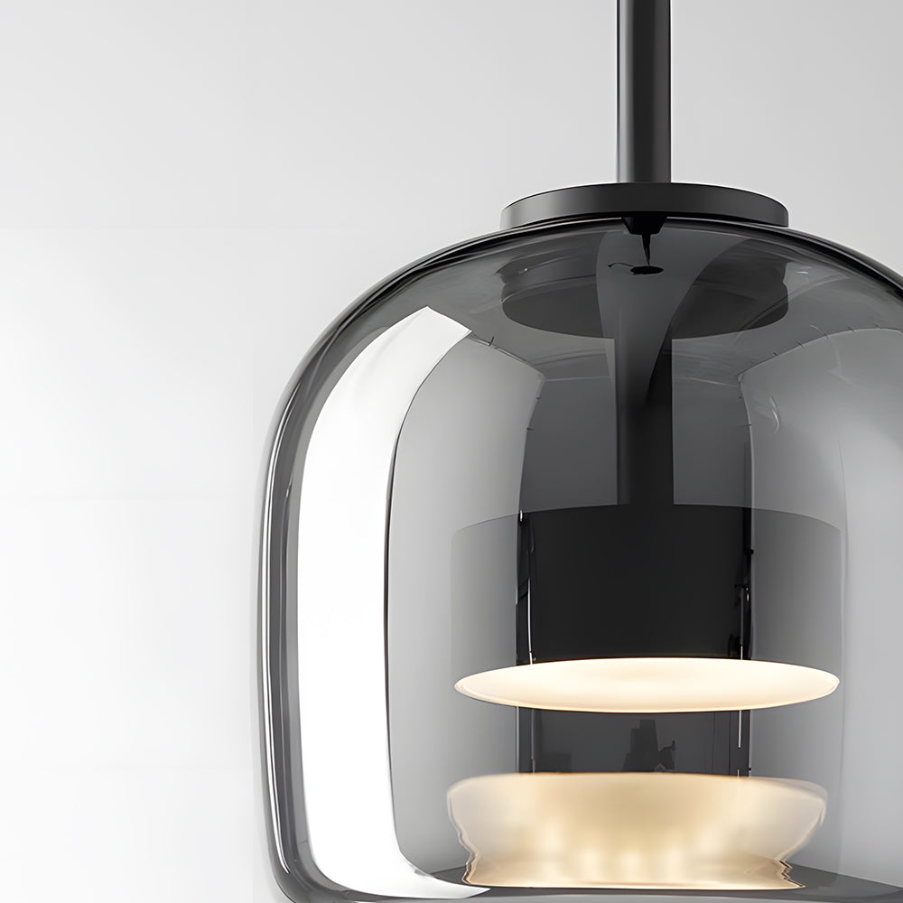 Close-up of the Nordic Glow smoked grey glass LED pendant light, showcasing its minimalist design, illuminated warm light, and black internal fixture.