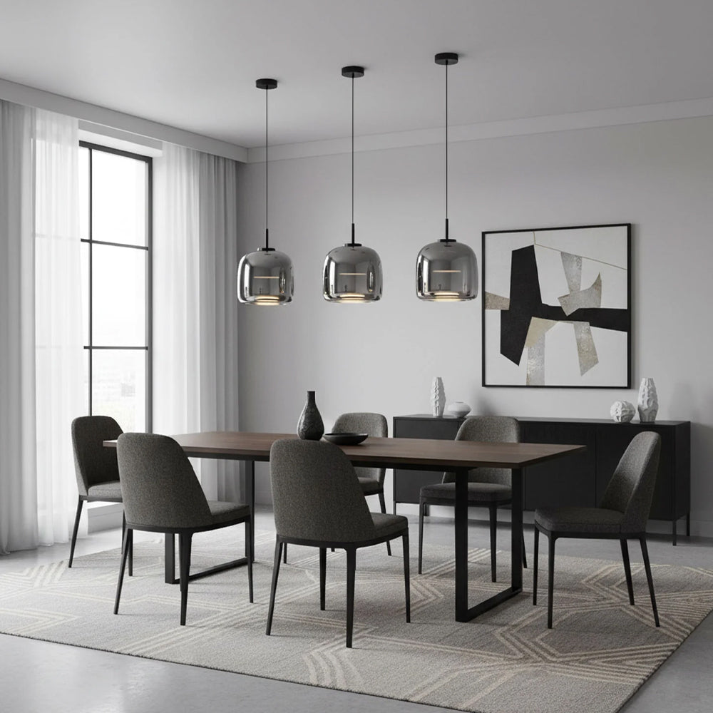 A modern dining room featuring three Nordic Glow smoked glass LED pendant lights in grey, hanging above a long wooden dining table. The minimalist design of the pendant lights complements the contemporary decor, providing stylish ambient lighting.