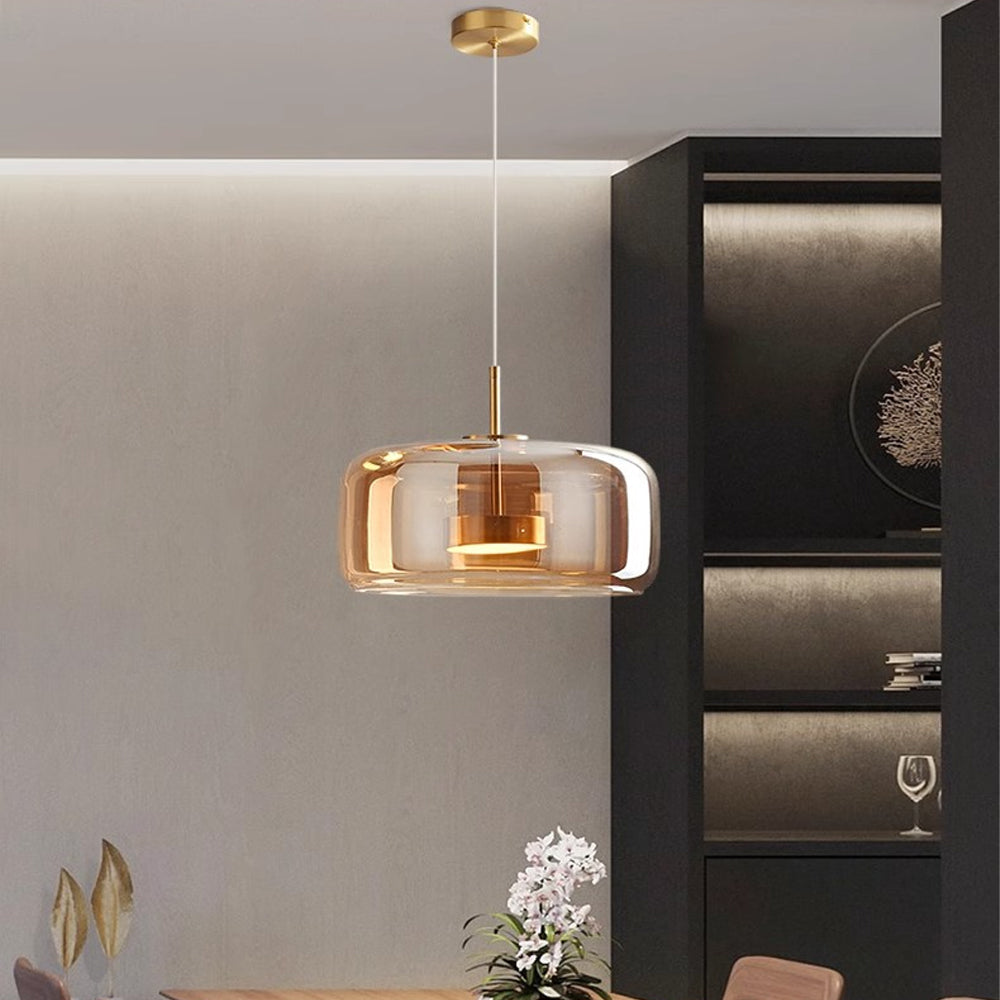 Nordic Glow smoked glass LED pendant light with minimalist design, featuring an amber glass shade and warm glow, hanging in a modern dining room above a table with white flowers.