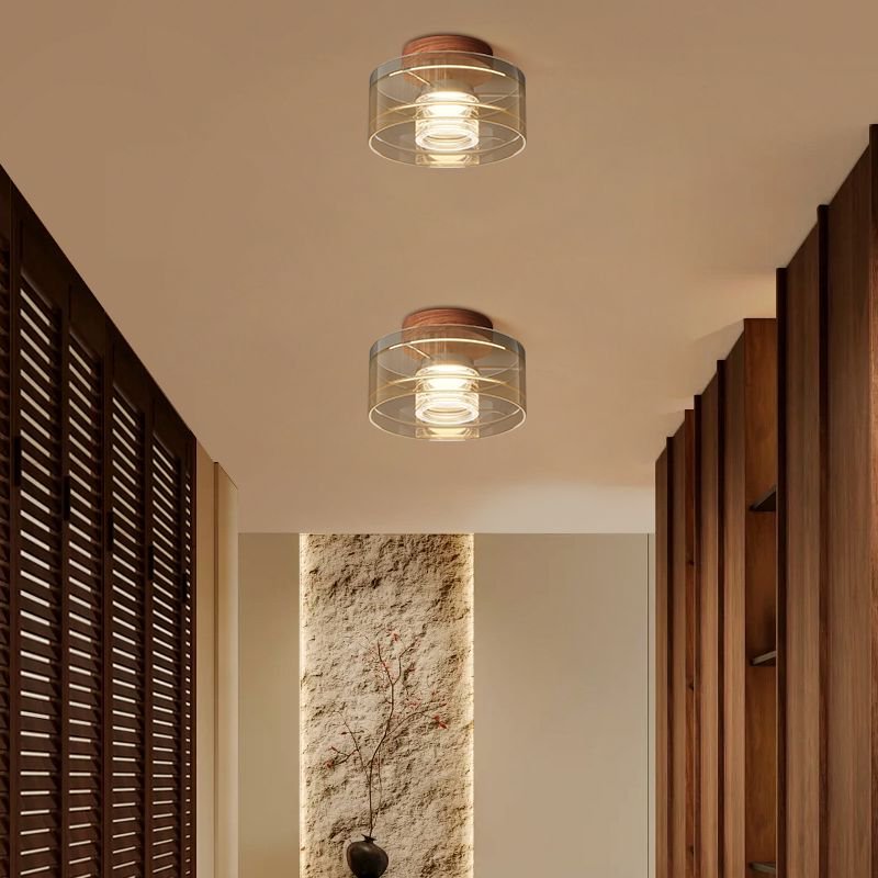 Modern Italian black aluminum LED ceiling light with black base front view showing clear glass shade lit softly