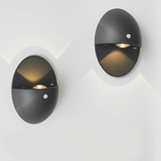 Oval Shape Motion Sensor Wall Light Sconce two modern lights on a white wall.