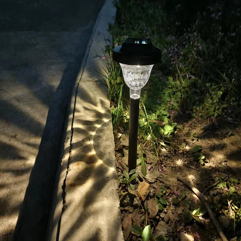 Close-up of PP Round Solar Light Sensor glowing warm light with shadow projection lit on outdoor lawn