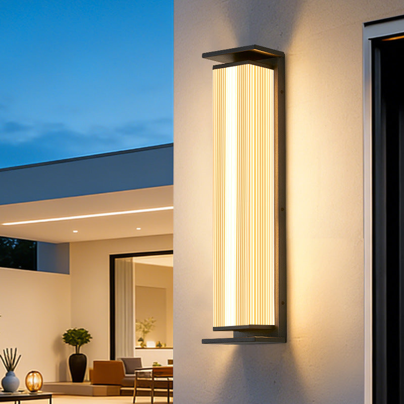 Side profile of stainless steel vertical ribbed waterproof LED outdoor wall sconce glowing cool white light with powder coating finish