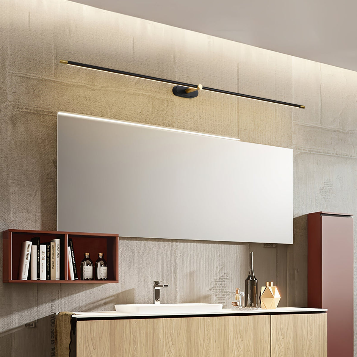 A Vestra Minimalist Linear Rechargeable Wall Lamp in black with gold accents, angled above a large rectangular mirror in a modern bathroom, featuring a wooden vanity, sink, and decorative elements.