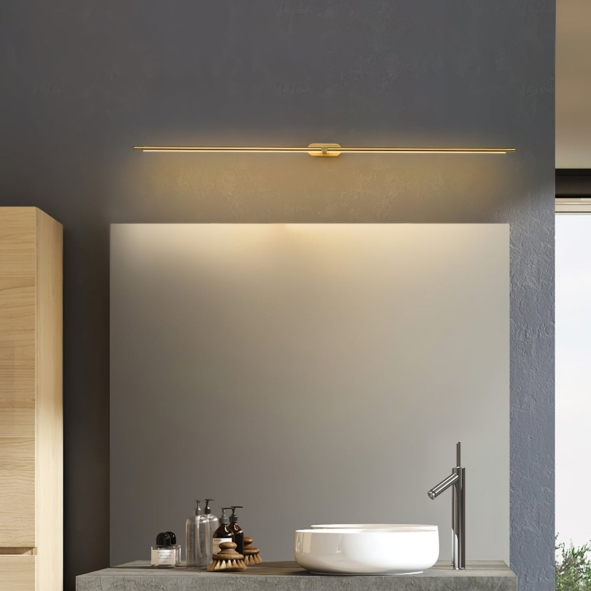 Vestra Minimalist Linear Rechargeable Wall Lamp Metal with LED Finish in gold, illuminated above a sink and mirror in a modern bathroom.