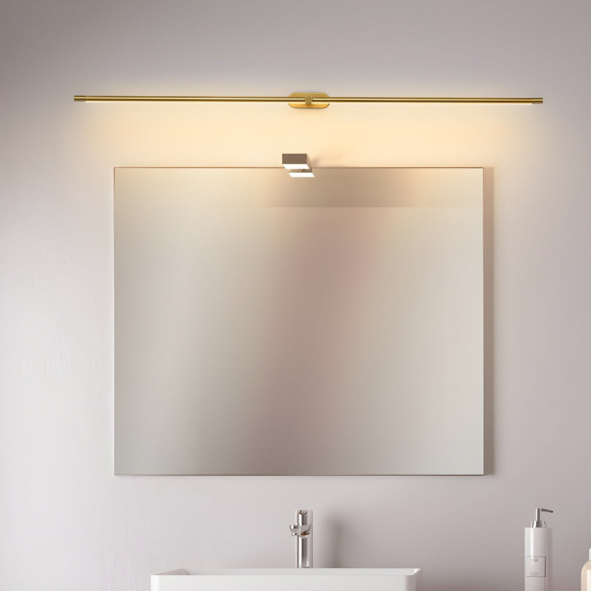 Vestra Minimalist Linear Rechargeable Wall Lamp in gold finish, mounted above a square mirror in a modern bathroom with a white sink.