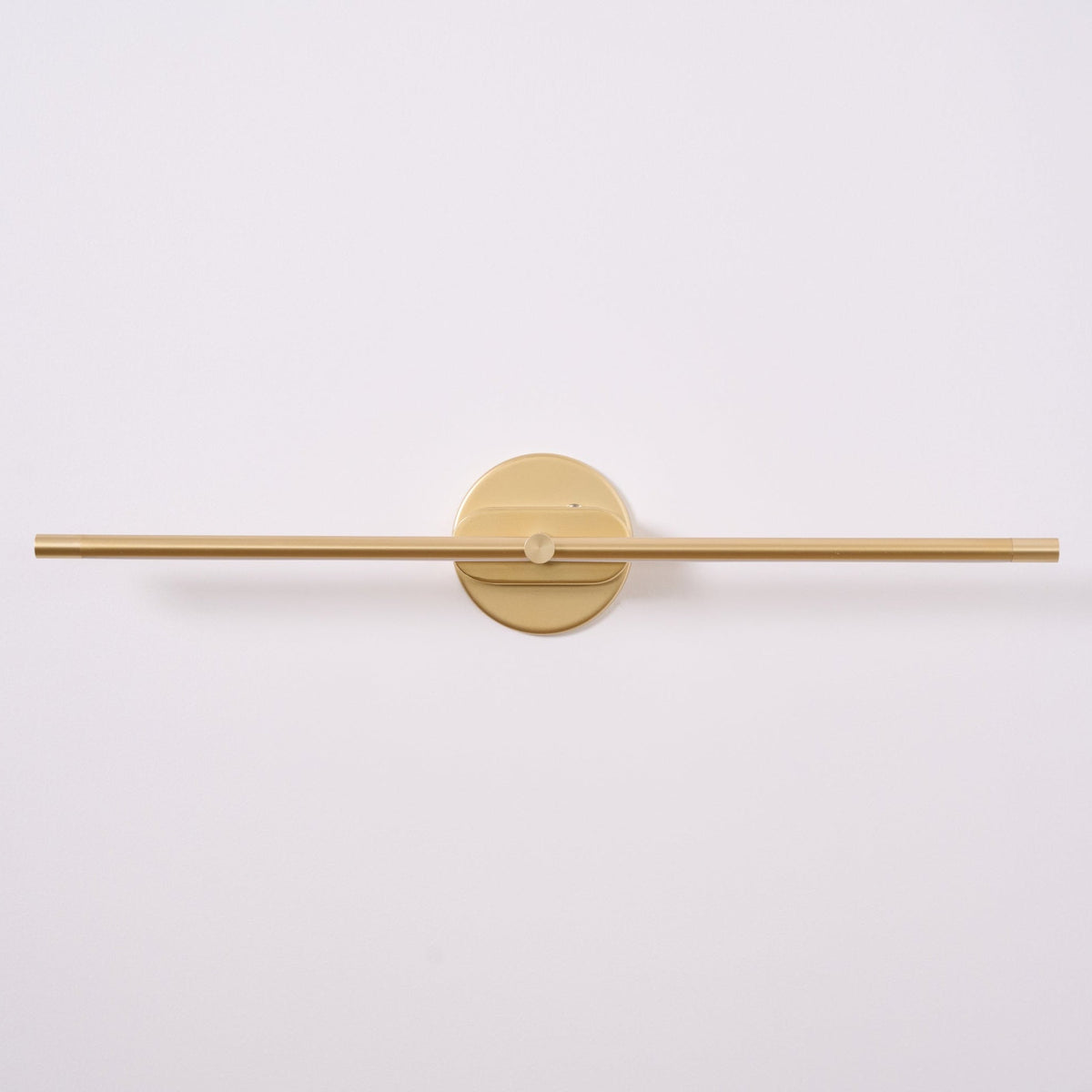 A Vestra Minimalist Linear Rechargeable Wall Lamp in gold finish, unlit, featuring a sleek linear design a circular mounting base, presented against a plain white background.