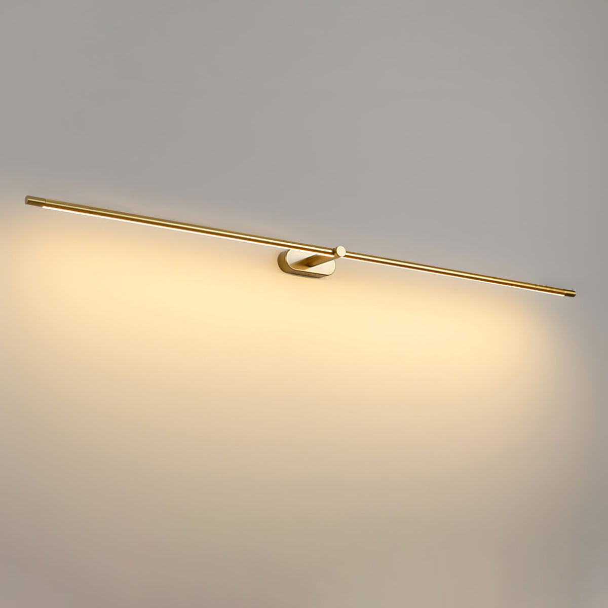 A Vestra minimalist linear rechargeable wall lamp in gold metal finish, illuminated with warm LED light, mounted on a light grey wall.
