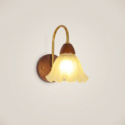 Eye-level view of walnut wood single-head mid-century wall sconce with walnut finish in minimalist bedroom setting